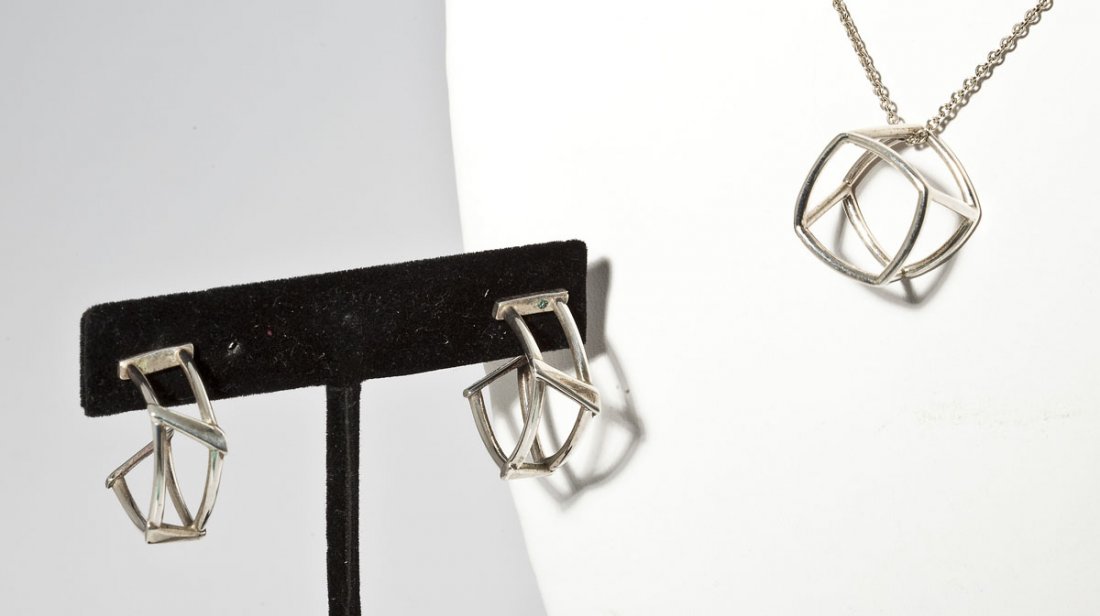 Tiffany F. Gehry Open Torque Earrings & Pendant: DESCRIPTION: Marked "T&Co. 925 Gehry" Open Torque pierced earrings and pendant by Frank Gehry for Tiffany. Open Torque pendant on cable chain. Includes Tiffany ultrasuede bag. MEASUREMENTS: Earrings 7