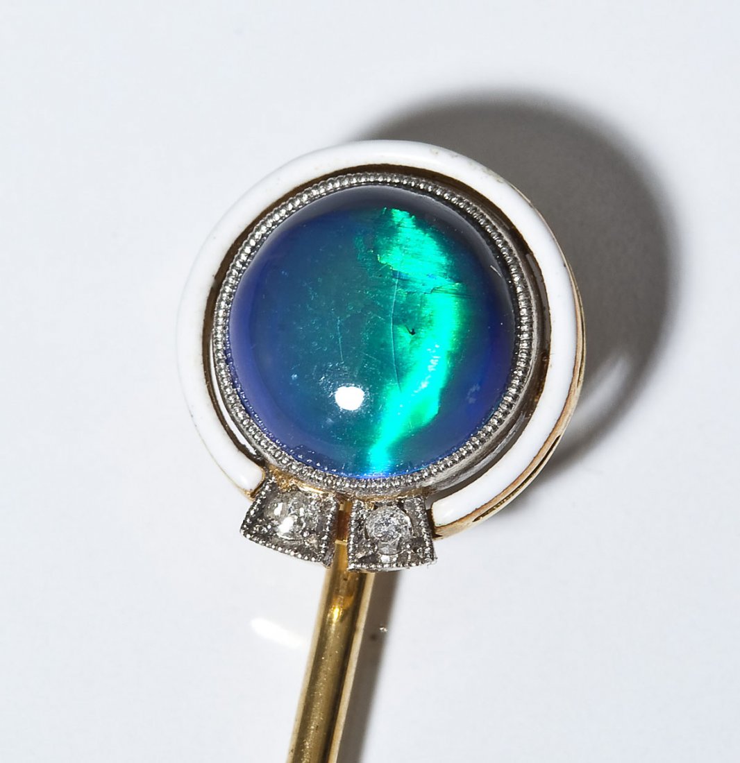 16K Opal Cat's Eye & Diamond Stick Pin: DESCRIPTION: Tested 16K yellow gold stickpin. Set with a round opal cat's eye cabochon with white enamel frame and two approximately 2 point round diamonds. MEASUREMENTS: 2-3/4" long. 1.3 dwt (2.0 gr)