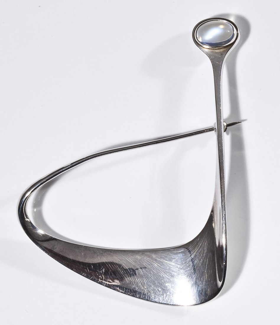 Georg Jensen Torun Bulow-Hube Brooch: DESCRIPTION: Torun Bulow-Hube for Georg Jensen modernist brooch. Signed "Torun Georg Jensen 925S Denmark 373". Set with oval moonstone. MEASUREMENTS: 2-5/8" x 3". CONDITION: Minor bend to pin.