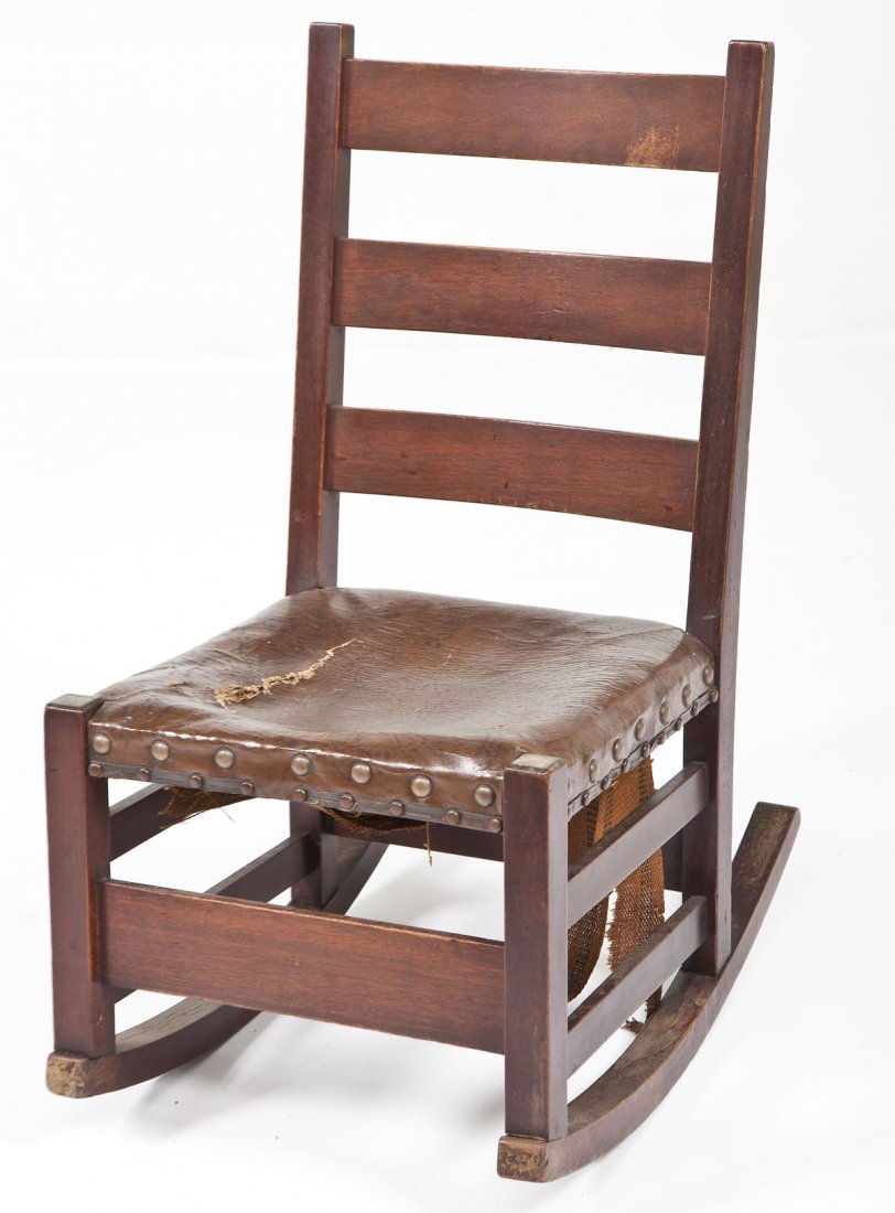 Signed L&JG Stickley Rocking Chair: DESCRIPTION: An American Arts and Crafts fumed oak rocking chair by L&JG Stickley. The form consisting of a box stretcher resting on two rockers rising to a leather over-upholstered seat (with attache