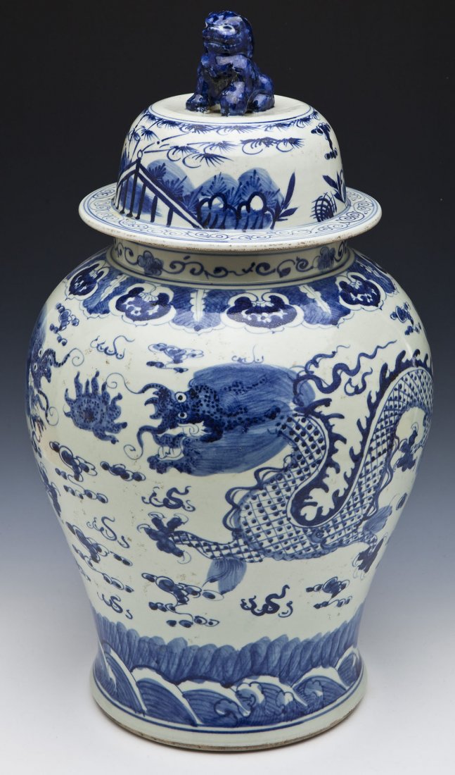 Large Chinese Blue & White Ginger Jar: DESCRIPTION: A large Chinese blue and white ginger jar decorated with dragons and a flaming pearl amongst clouds. Lid with figural foo dog finial. 20th century. MEASUREMENTS: 22-1/2" high. CONDITION: 