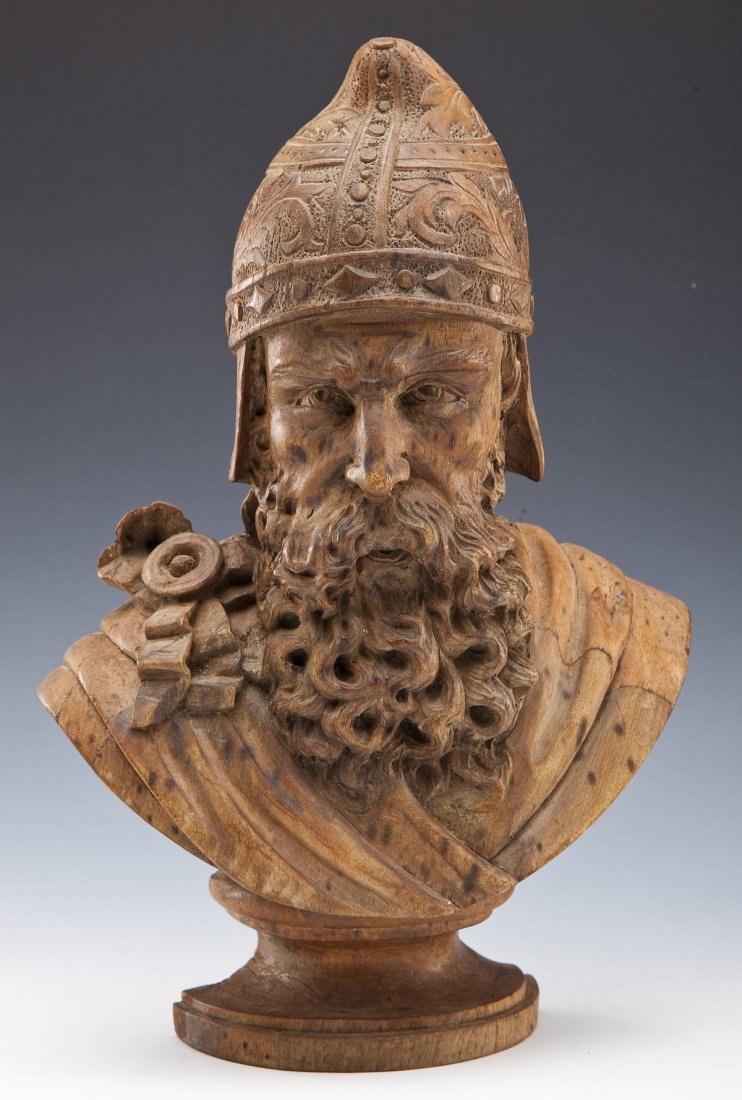 Carved Wood Bust of Soldier: DESCRIPTION: Carved wood bust of a soldier in conical cap and cloak pinned at shoulder. MEASUREMENTS: 10" x 15" high. CONDITION: Overall patina. Minor separation at seam along right side of face.