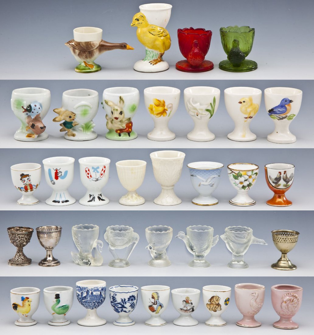 36 Vintage Egg Cups: DESCRIPTION: Group of thirty-six vintage glass and porcelain egg cups including Belleek, Lenox, Japan, figural, Goebel, Bing & Grondahl, silver plated and more. MEASUREMENTS: Ranging from 2" to 4". CO