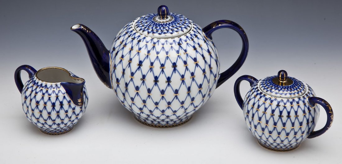 Lomonosov Cobalt Net Russian Tea Set: DESCRIPTION: Lomonosov tea set. Cobalt net pattern. Includes: one 7" teapot, one 4-1/2" lidded sugar, and one 3-1/2" creamer. Each marked underneath with Lomonosov mark and "Made in Russia". MEASUREME