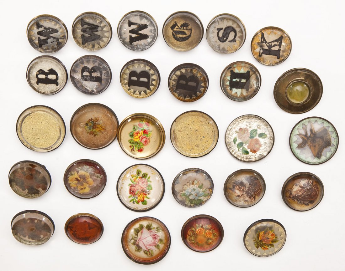 29 Vintage Horse Bridle Enamel Rosettes: DESCRIPTION: Twenty-nine vintage horse bridle rosettes. Each in metal and enamel/lucite. Includes florals and letters. MEASUREMENTS: Various sizes. CONDITION: Rusting to metal, pitting, some scratchin
