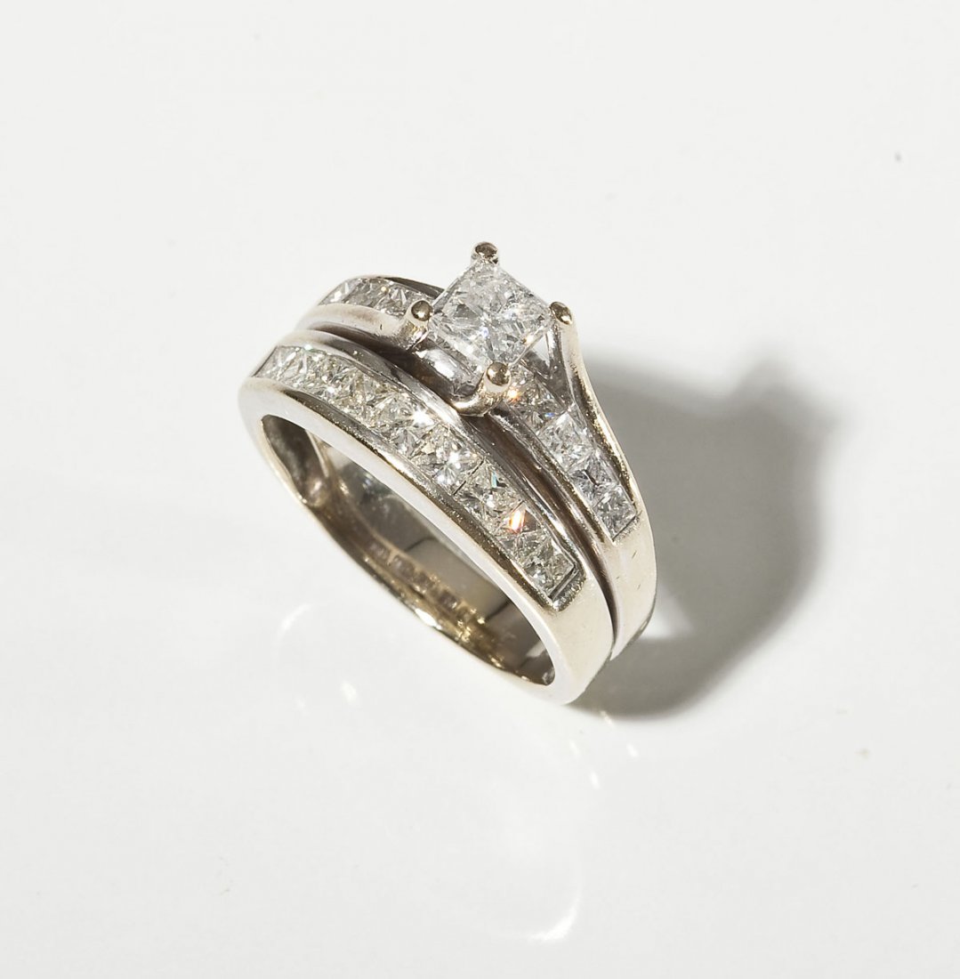 1.71 CTW Diamond Wedding Set: DESCRIPTION: Tested 14K white gold engagement and wedding ring soldered together. Set with one .46 carat princess cut diamond (clarity I1, color I-J) in trellis setting with ten channel set graduated 