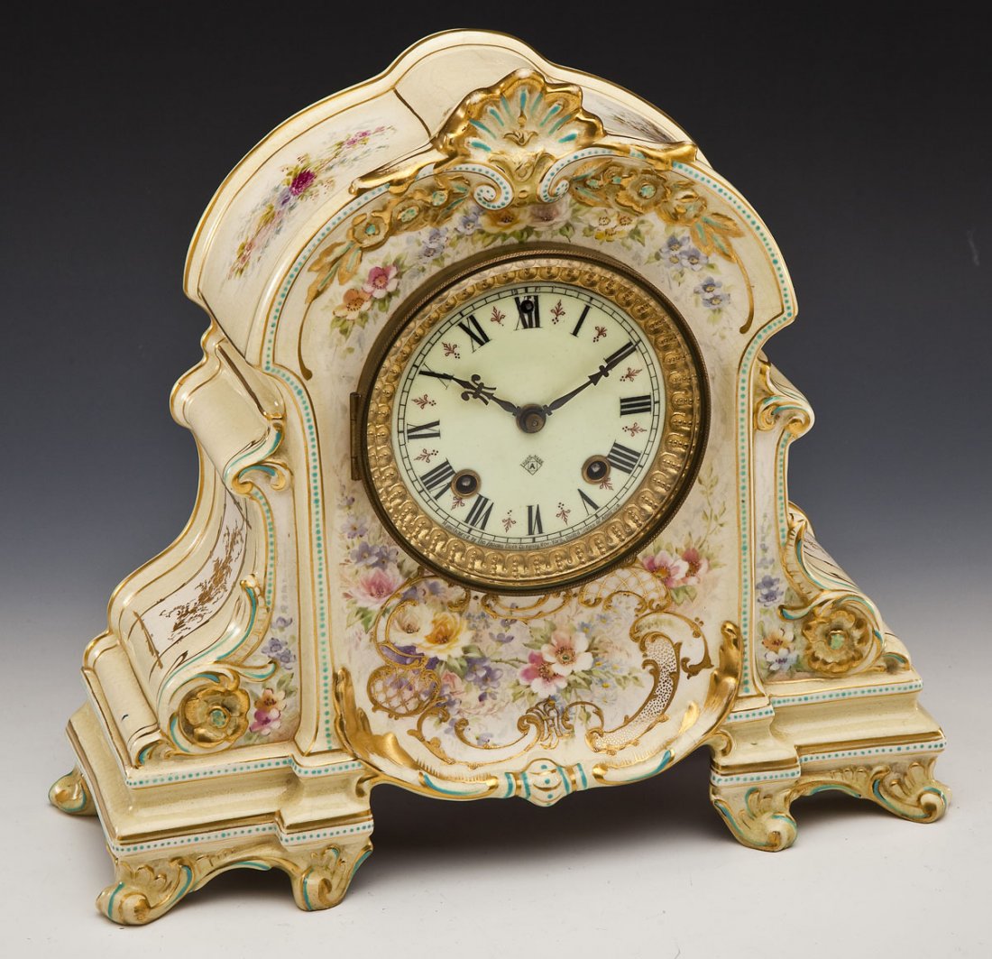 Ansonia Royal Bonn Porcelain Mantle Clock: DESCRIPTION: Royal Bonn porcelain mantle clock with Ansonia clockworks. Soft yellow color with blue accents,pink and purple floral motifs, and gold flourishes. Dial marked with Ansonia Trade Mark and 
