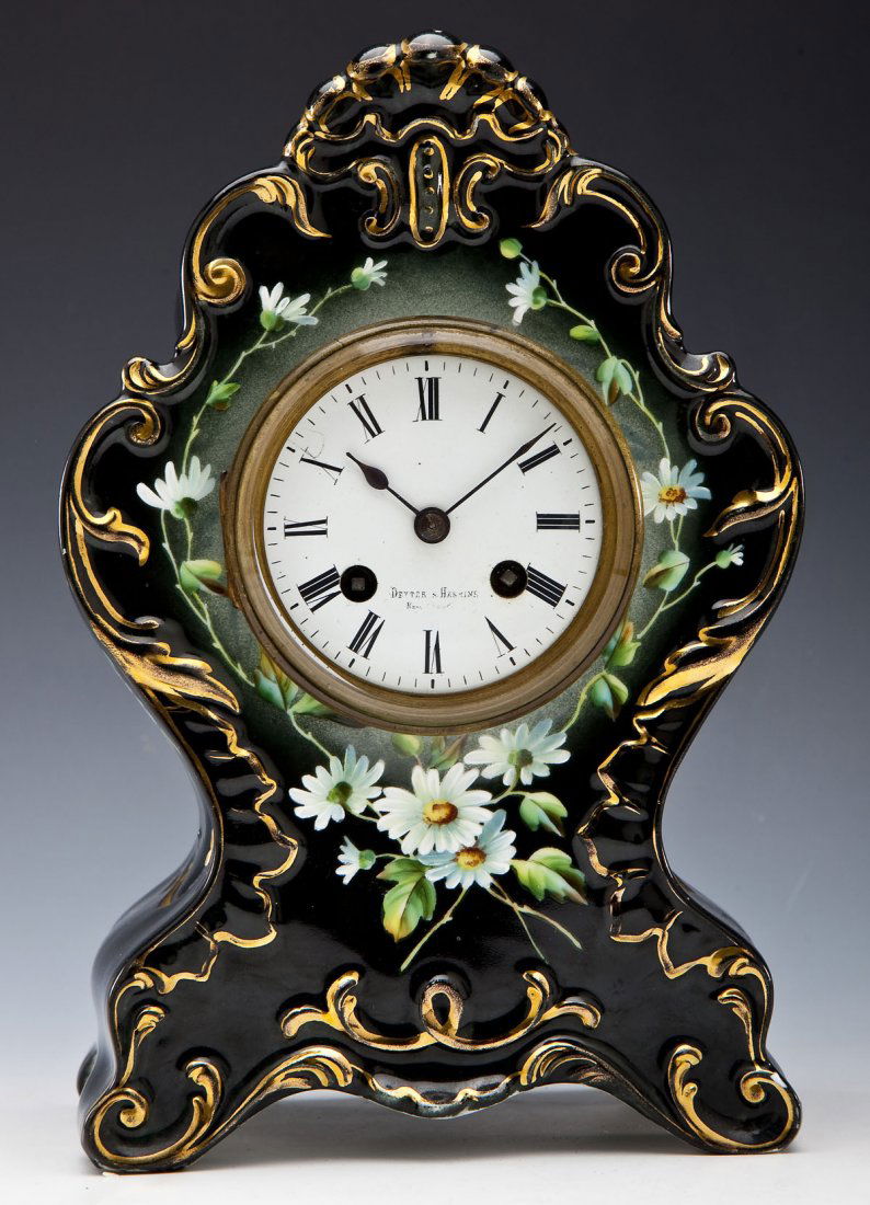 Carlsbad Austrian China Dexter and Haskins Clock: DESCRIPTION: Carlsbad Austrian China clock retailed by Dexter and Haskins. Black glaze with gold accents and painted daisies. Roman numerals on dial, marked with "Dexter and Haskins". Brass coverplate
