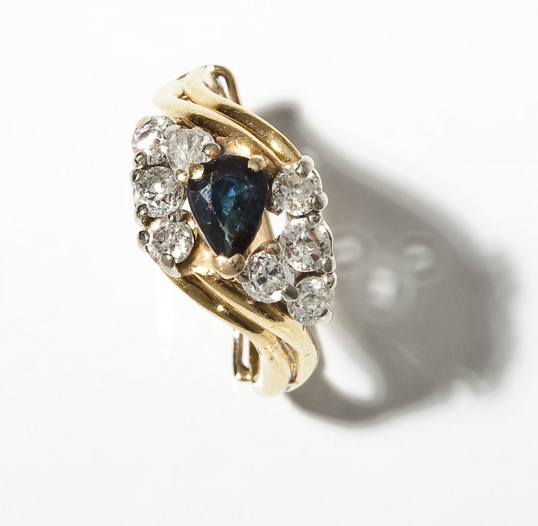 18K Sapphire & Diamond Ring: DESCRIPTION: Bypass style split shank yellow gold fashion ring. Set with one .67 carat blue sapphire and eight .10 to .13 carat Old European cut round diamonds. Clarity SI to I1, color H-J. Hinged gol