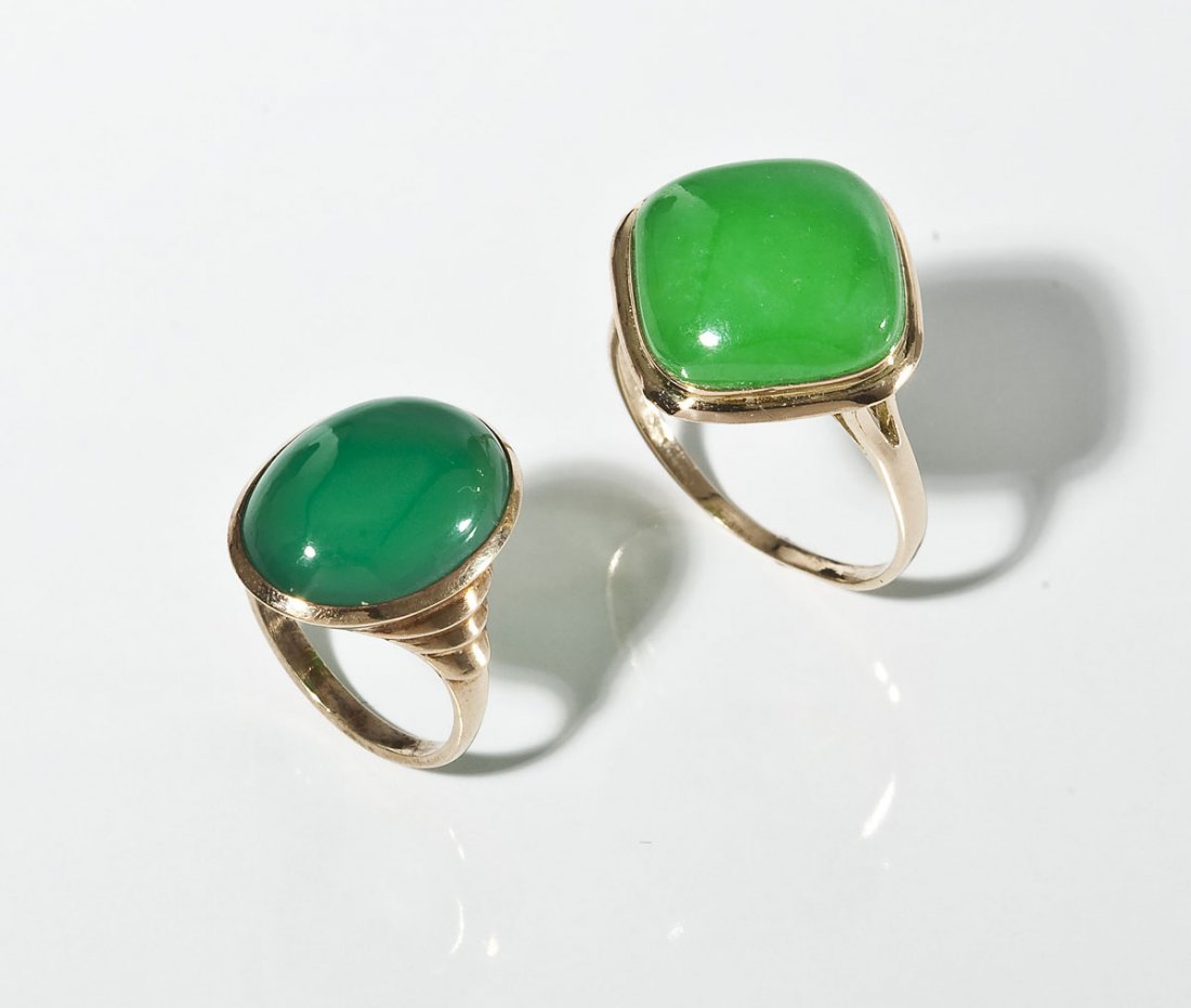 2 Gold & Green Stone Rings incl Jade: DESCRIPTION: Two gold and green stone rings. Includes: 1) Marked 10K yellow gold ring set with dark green oval cabochon chalcedony. Size 5. 2.2 dwt (3.4 gr). 2) Marked 14K yellow gold ring set with an
