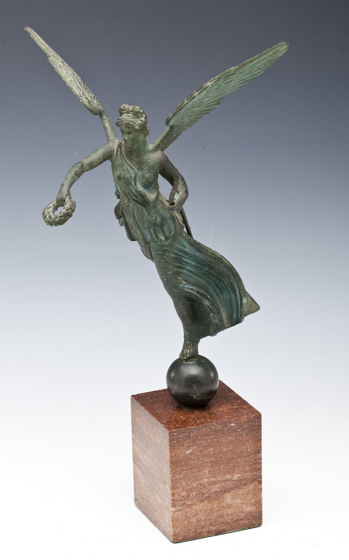 Bronze Nike on Marble Base: DESCRIPTION: Bronze Nike on red marble base. Bronze cast "Winged Victory" or Nike balances on a sphere holding a staff and a laurel crown. MEASUREMENTS: Approximately 13-1/2" tall x 5-1/2" wide includ