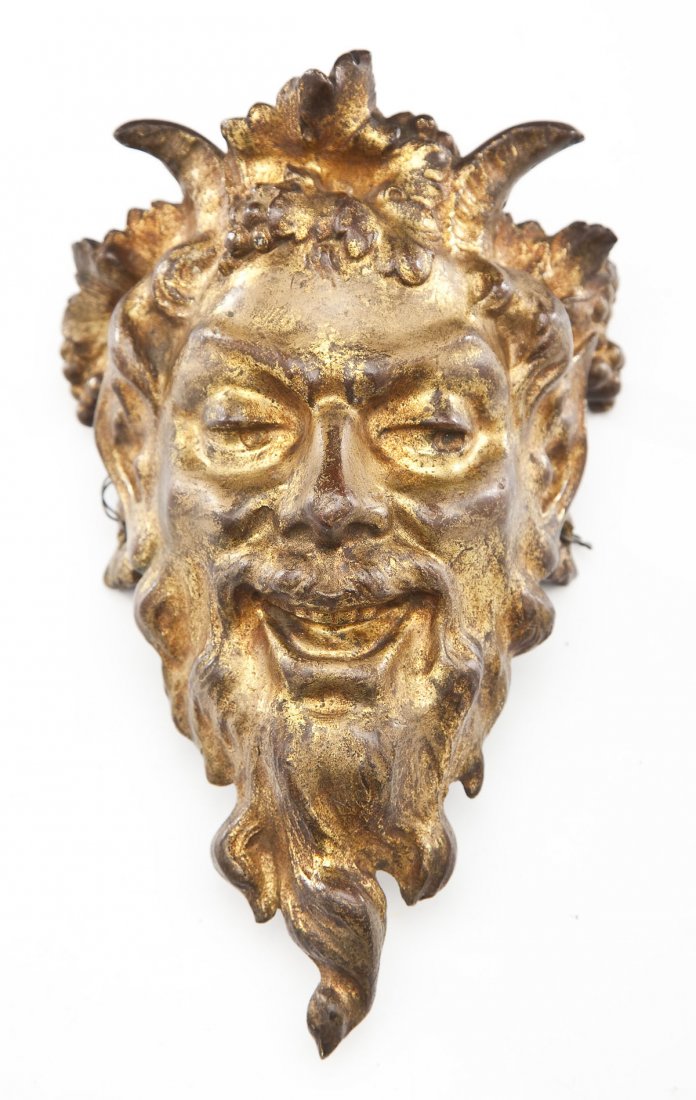 Gilt Bronze Face of a Satyr: DESCRIPTION: Gilt bronze face of satyr with a sly look on his face. "8" stamped into the inside of reverse. Holes on side for hanging. MEASUREMENTS: 7-1/2" x 4-1/4". CONDITION: Minor wear throughout c