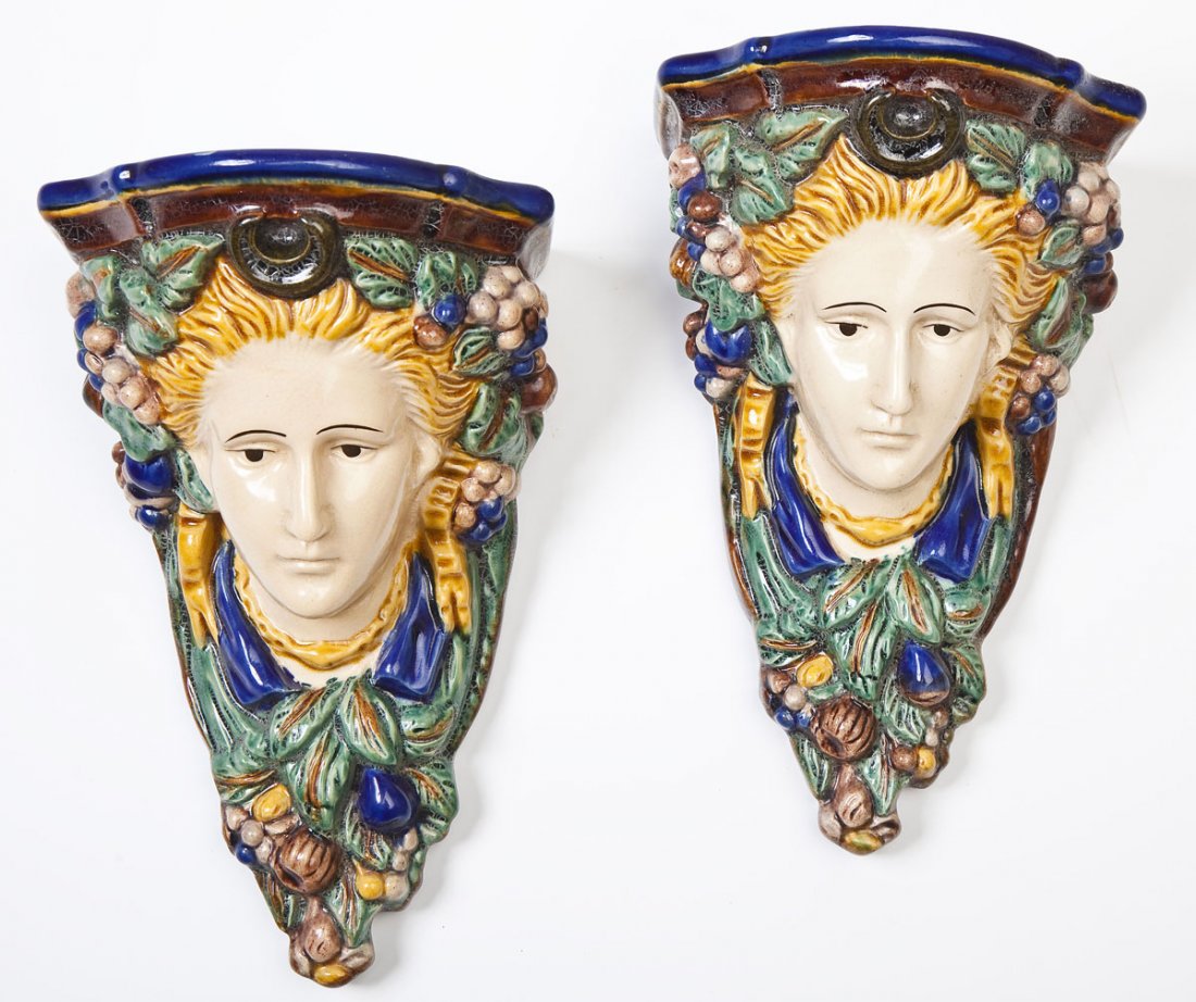 Pair of Majolica Figural Sconce Shelves: DESCRIPTION: Pair of ceramic figural sconce shelves. Painted with green, yellow, cobalt, and brown-purple. Blonde-haired women surrounded with greenery and fruit, topped with horseshoe shape. Two hole