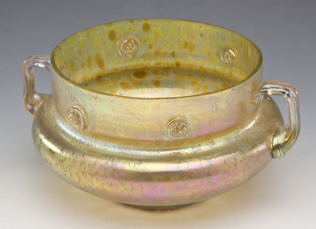 Loetz Type Iridescent Double-Handled Bowl: DESCRIPTION: Loetz type art glass gold iridescent double-handled bowl with small raised glass medallions. MEASUREMENTS: 9-1/4" handle edge to handle edge x 6-7/8" diameter x 4-3/4" tall. CONDITION: Mi