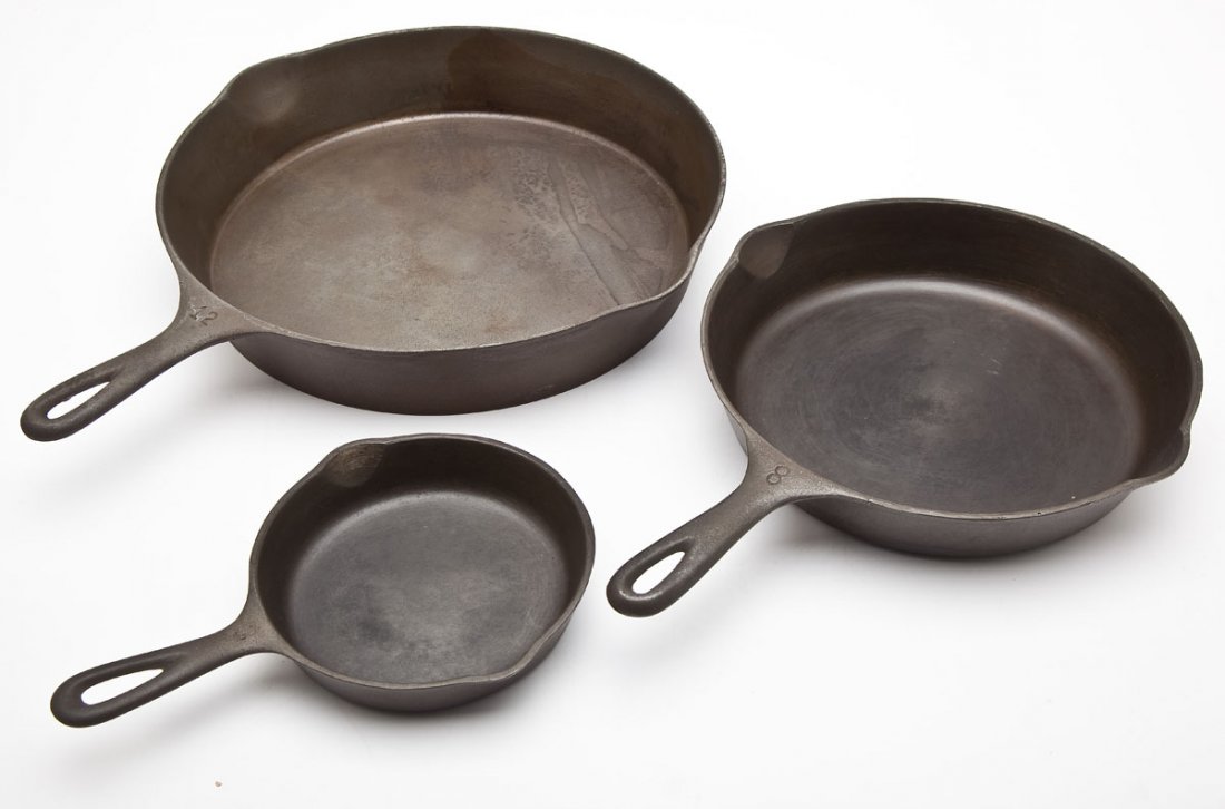 3 Wagner Skillets: DESCRIPTION: Three Wagner skillets. Includes: 1) Wagner No. 12 Skillet, Stylized Logo. Catalog/Part No: 1062; 18-1/4" long. 2) Wagner No. 8 Skillet, Stylized Logo. Catalog/Part No: 1058I; 15-1/4" long