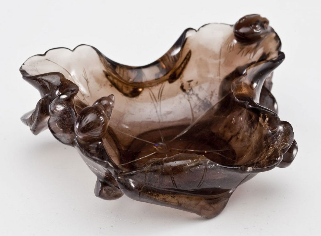 Chinese Smoky Quartz Brush Washer: DESCRIPTION: Chinese smoky quartz brush washer. Carved in the shape of a folded leaf with a tiny bird and a frog. MEASUREMENTS: 3-3/4" wide x 2" tall x 3" long. CONDITION: Minor crack on foot of base.