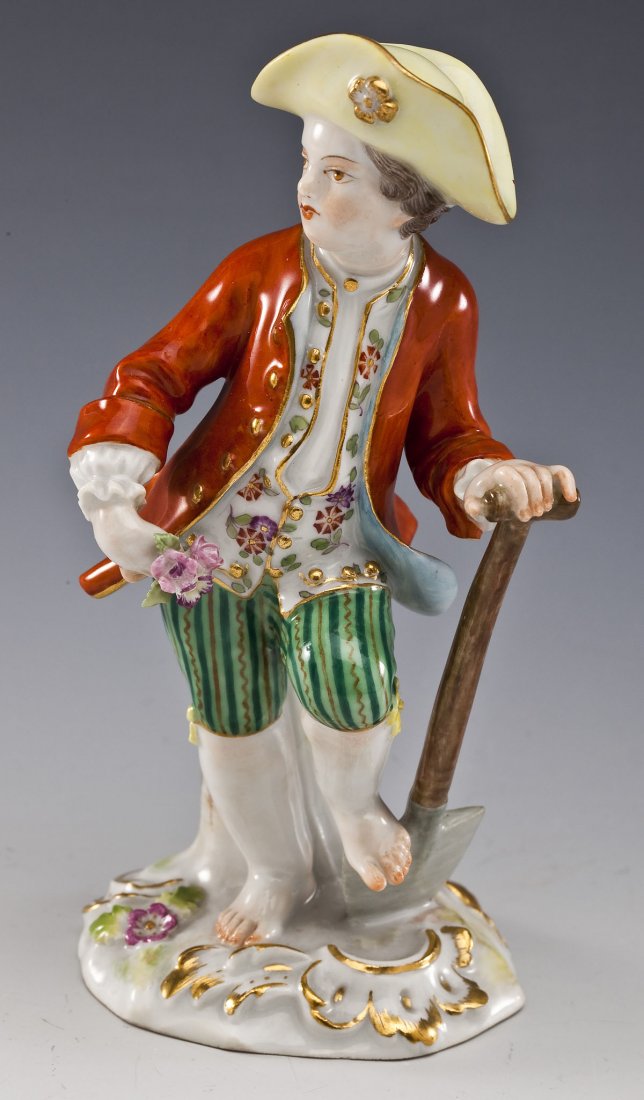 Meissen Figurine of Child Gardener with Shovel: DESCRIPTION: Meissen figurine of child gardener in 18th century clothing with shovel. Figure is barefoot. and leaning against a stump. Meissen crossed sabers mark on underside. MEASUREMENTS: 5-1/2" ta