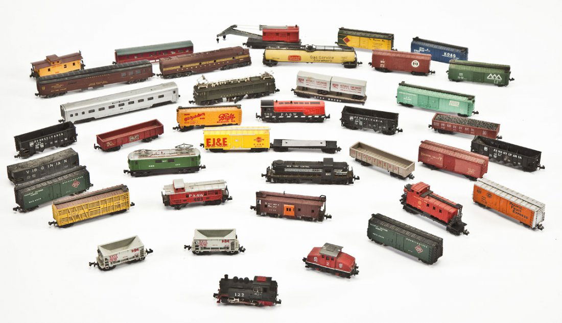 38 N Scale Cars & Locomotives: DESCRIPTION: Thirty-eight N scale train cars and locomotives. Includes but not limited to boxcars, locomotives, coal cars, flat cars, a crane car, and tanker cars. MEASUREMENTS: Each between 3" and 7"