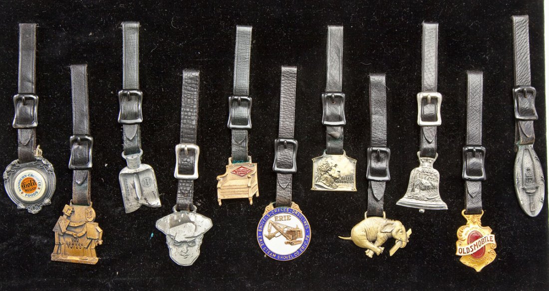 11 Vintage Advertising Watchfobs: DESCRIPTION: Eleven vintage advertising watchfobs. Includes: Washburn-Crosby, The Lumber Twins, Pelco, Olizum, Tomlinson Quality, Erie Steam Shovel Co., George Washington, The Keystone Lumber Co., Cam