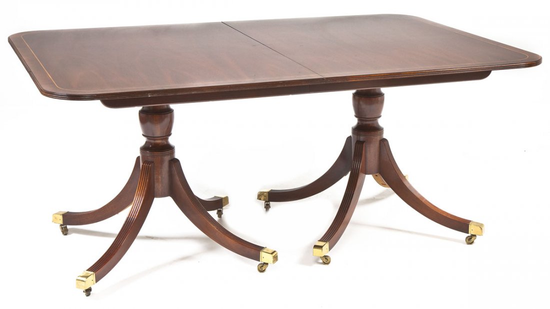 Baker Charleston Extension Table: DESCRIPTION: A Duncan Phyfe style double pillar extension table made by Baker and retailed by the Historic Charleston (SC) collection. The form consisting of brass capped toes joined to four reeded le