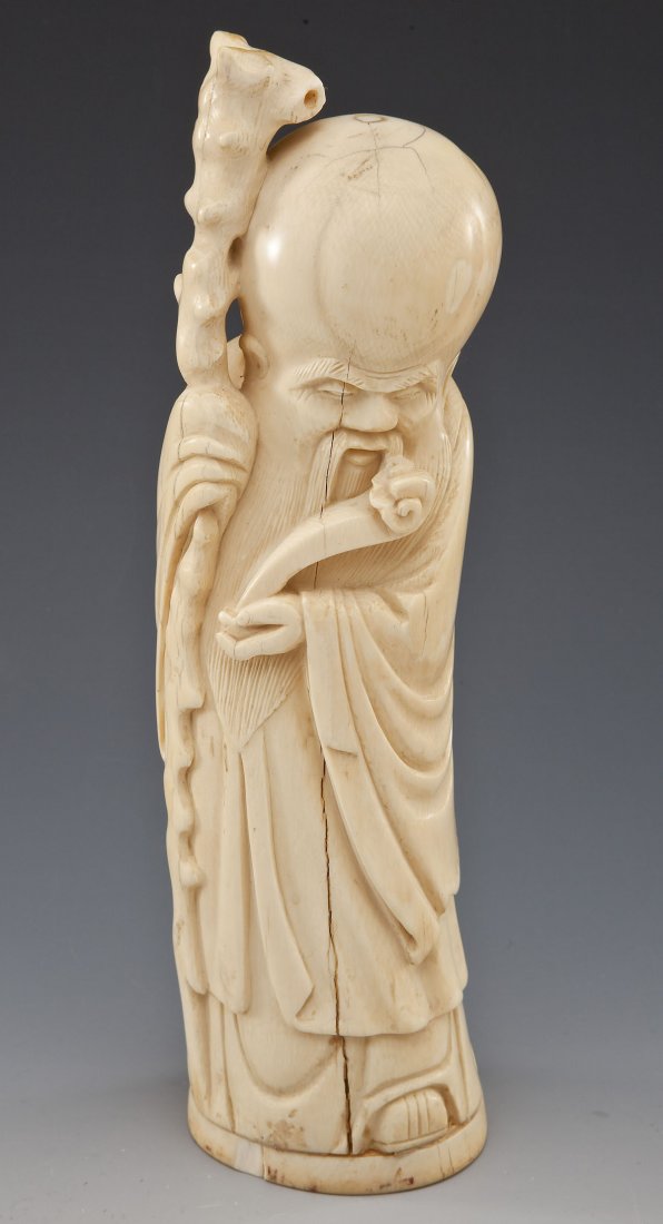 Carved Ivory Tusk of Shou-Lao: DESCRIPTION: Carved ivory tusk of Shou-Lao holding staff and ruyi (scepter). Chop marks underside of base. MEASUREMENTS: 10-1/4" tall. CONDITION: Minor wear as expected with handling. Hairlines and cr