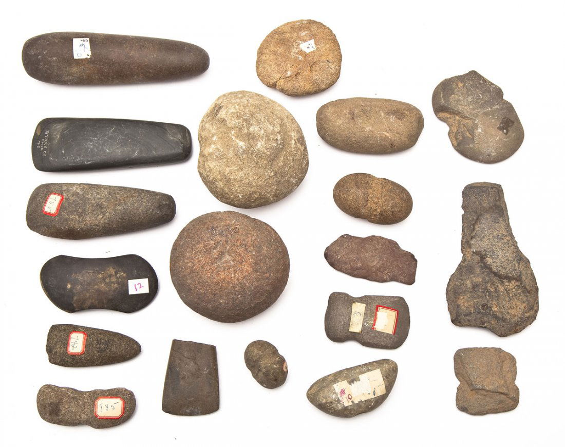 18 Native American Stone Tools: DESCRIPTION: Eighteen Native American stone tools. Includes 3 adzes, the tip of a broken adze, 3 club heads, 3 nutting stones, 1 pestle, 1 gorget, 2 unfinished gorgets, and 4 eroded or broken sinker s
