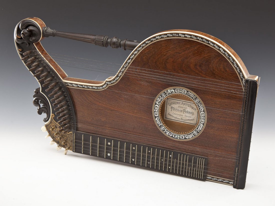 19th C. Foetisch Freres Zither: DESCRIPTION: 19th century Foetisch Freres Zither. Wooden body with mother of pearl inlay, carved architectural style elements, bone tuning knobs, and metal strings. Label to soundhole: "Lutherie Artis