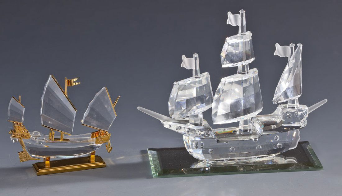 2 Swarovski Ships: DESCRIPTION: Two Swarovski crystal ships. In original boxes. Each marked with Swarovski swan to base. Includes: 1) Junk with brass stand. 2-1/4" x 2-5/8". 2) Santa Maria Galleon with rectangular mirro