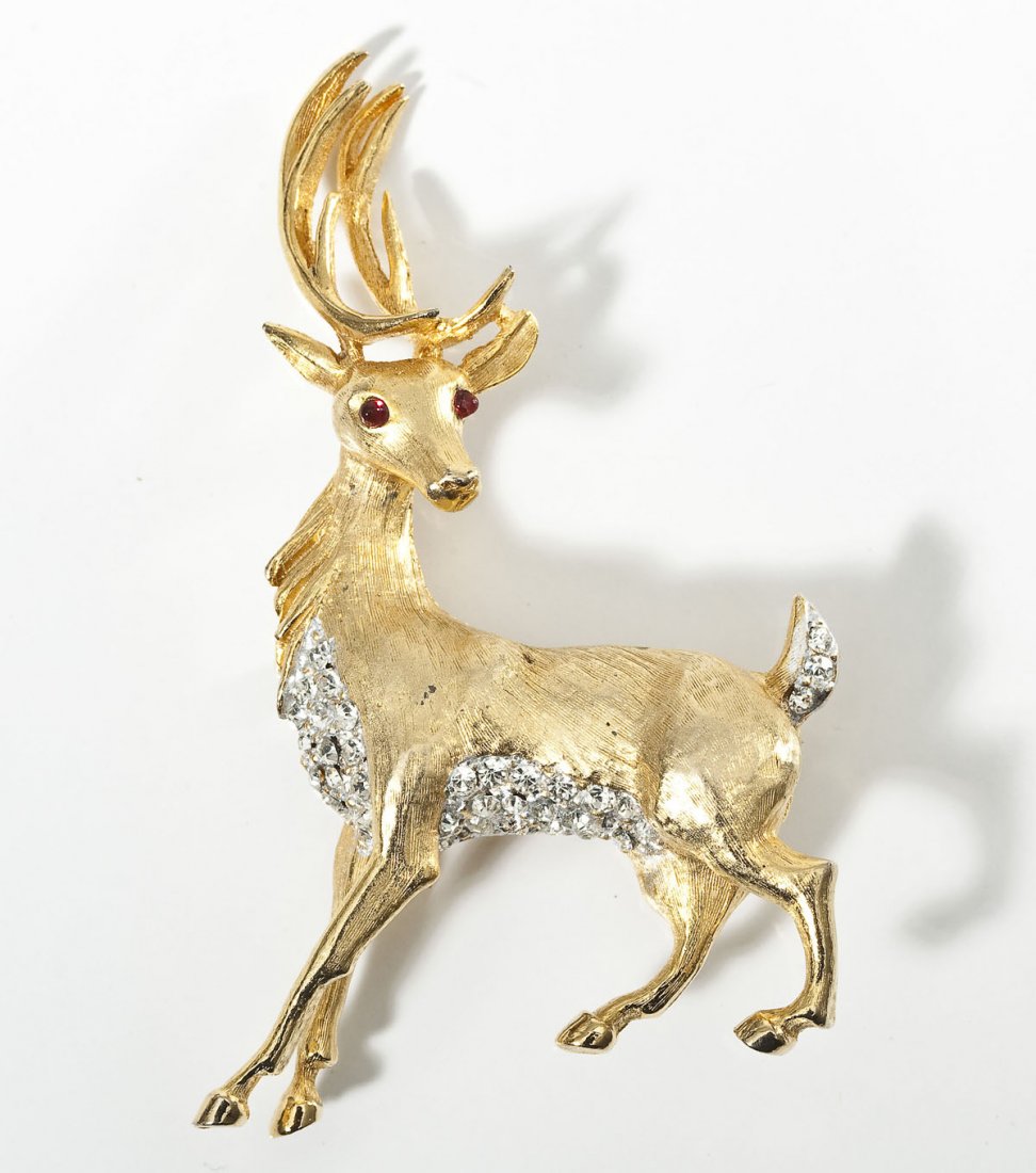 Hattie Carnegie Deer Pin: DESCRIPTION: Deer pin with red glass eyes and rhinestone accents. Marked for Hattie Carnegie. MEASUREMENTS: Approx. 3" high. CONDITION: No defects noted.