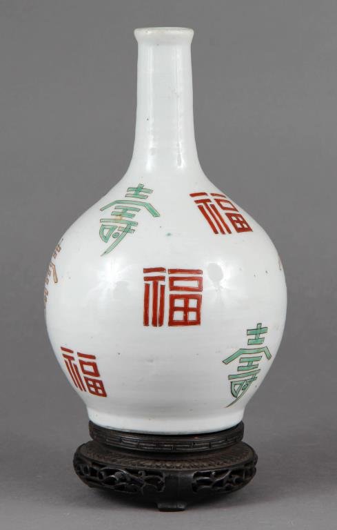 A Fine Antique Korean Porcelain Vase: Painted with colored symbols throughout, having remnants of paper to bottom of vase with multiple inscription, raised on finely carved hardwood stand, vase measures 8"H, circa 19th century.
