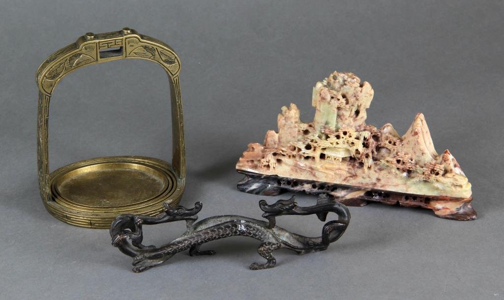 (3) Pieces Chinese Decorative Arts: To include a Chinese soapstone mountain, finely carved to depict a village scene, 7"W, a bronze two headed dragon, molded with fine detail, 6.5"W, and a brass caster set in the form of a stirrup, 5.5"