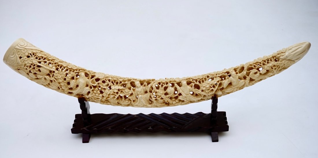 Faux Ivory Ornate Carved Tusk Chinese Pierced Signed Sc: Faux Ivory Ornate Carved Tusk Chinese Pierced Signed Scenic Carving on Stand Approximately 26 3/8 inches side to side.