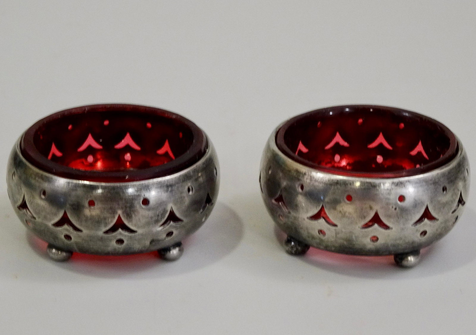 Open Salt Cellar Cranberry Glass Insert Hallmarked: Open Salt Cellar Cranberry Glass Insert Hallmarked Pierced Silver Plate Dish Approximately 1 7/8 inches in diameter x 3/4 inches tall.
