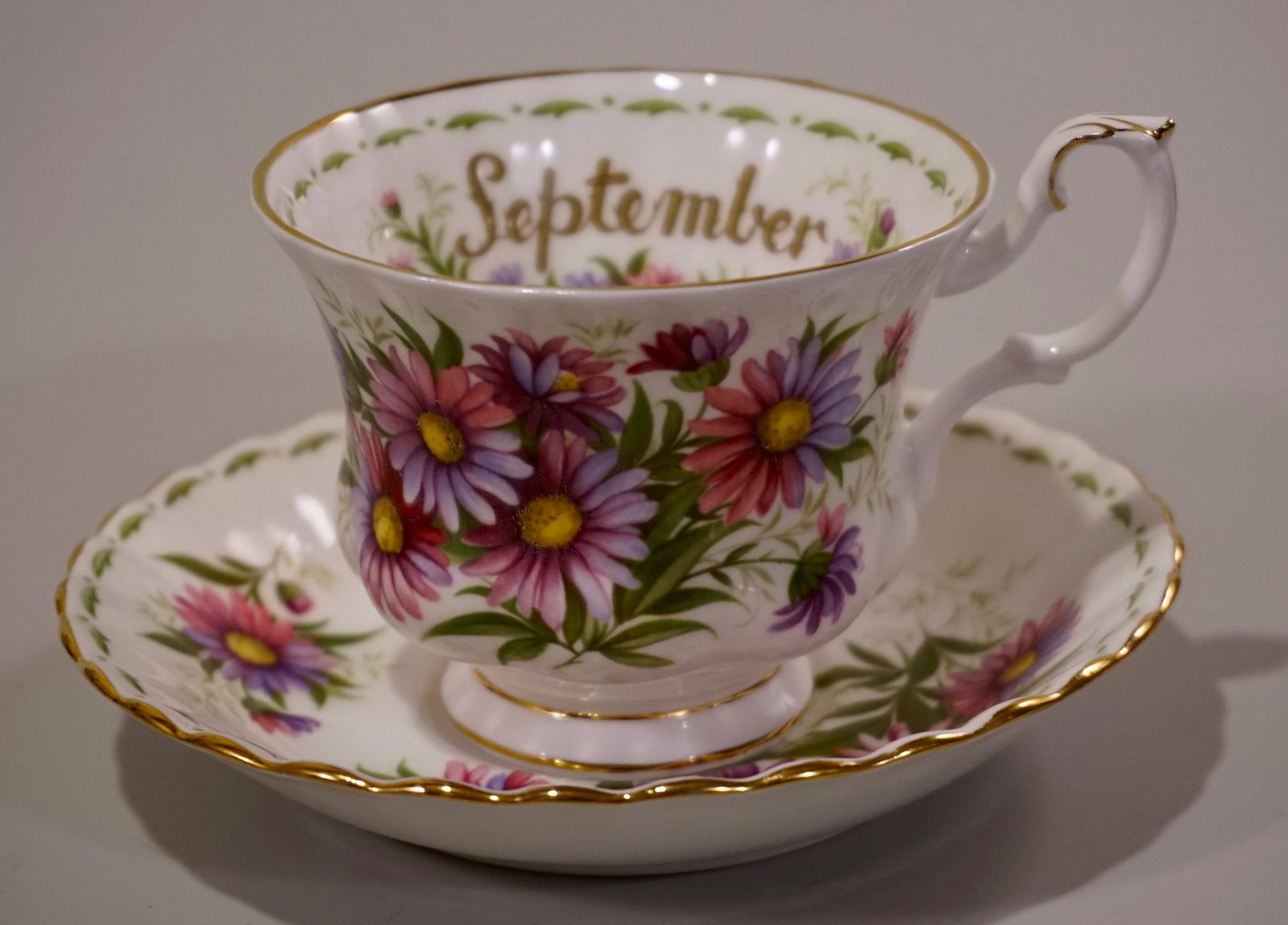 September Teacup Royal Albert Bone China England: September Teacup Royal Albert Bone China England Michaelmas Daisy Cup and Saucer Set Cup is approximately 4 _ x 3 9/16 x 2 _ inches; saucer approximately 5 _ inches in diameter.
