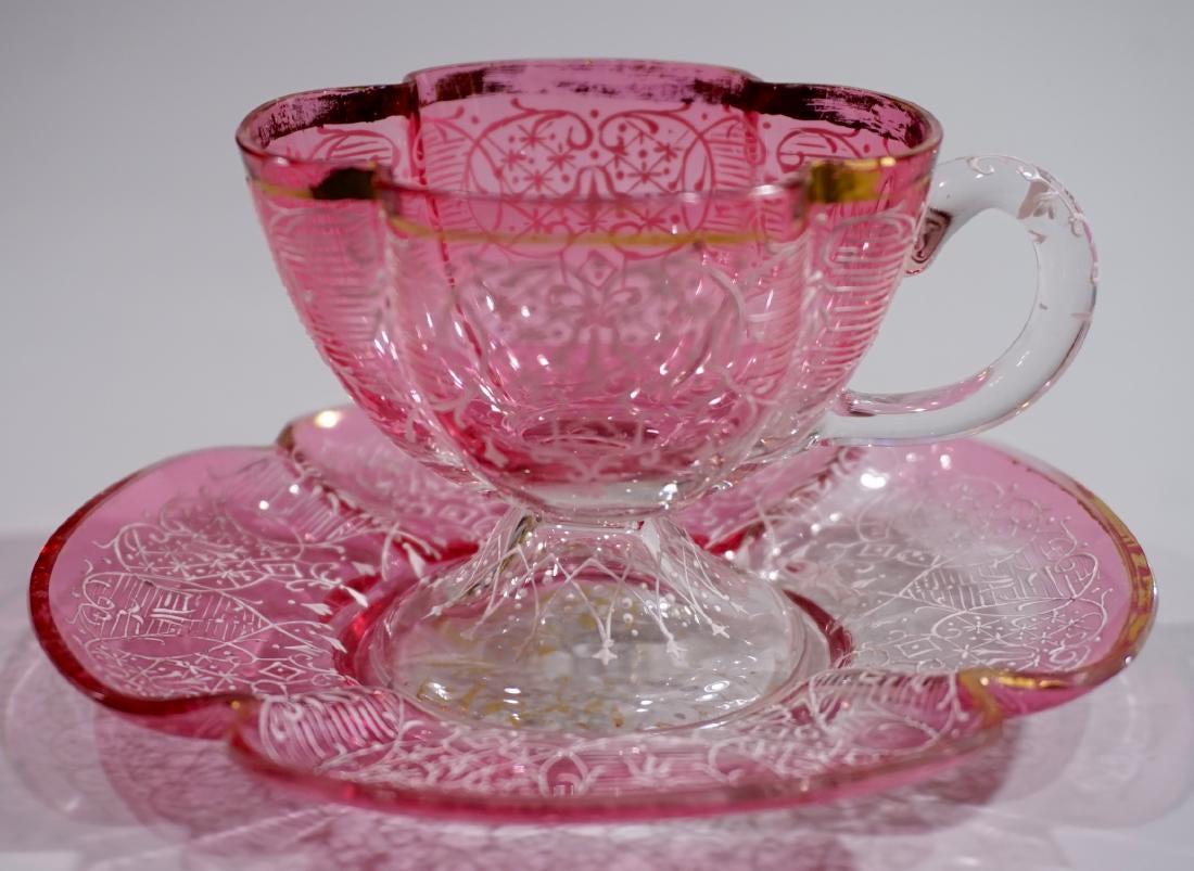 Antique Bohemian Art Glass Embossed Enamel Cranberry: Antique Bohemian Art Glass Embossed Enamel Cranberry Cup Saucer Set Cup is approximately 3 9/16 x 2 7/8 x 2 7/16 inches tall; saucer is about 4 3/4 inches in diameter.