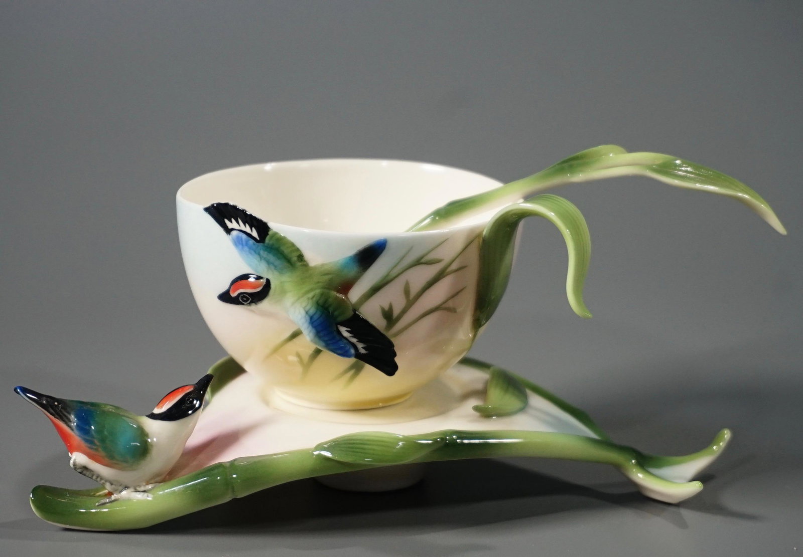 Franz China Figural Cup Saucer: Franz China Figural Cup Saucer The cup is 4 1/4 x 3 1/8 x 1 13/16 inches. The saucer is about 6 7/8 x 4 1/4 inches. The spoon is about 5 3/16 inches.