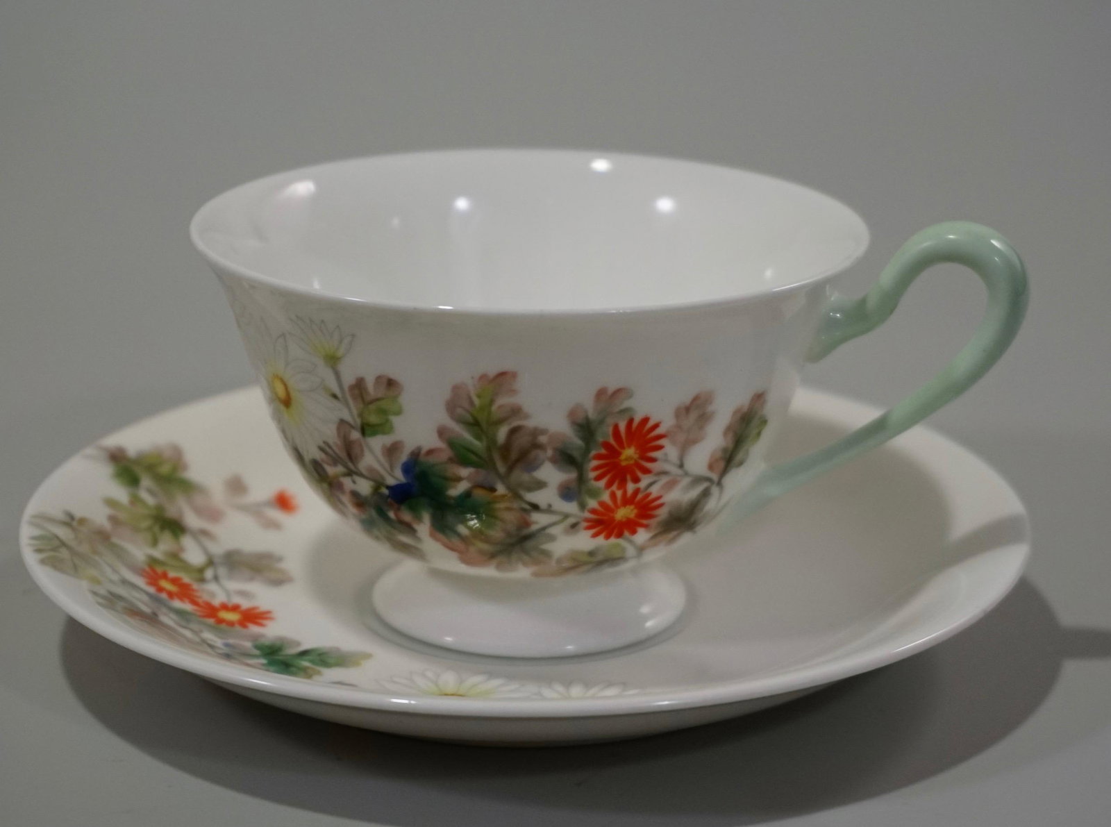 Nippon Toki Kaisha Bone China Tea Cup Saucer Raised: Nippon Toki Kaisha Bone China Tea Cup Saucer Raised Enamel Painted Daisy Flowers Saucer is approximately 5 15/16 inches in diameter; cup is about 4 13/16 x 3 15/16 x 2 5/16 inches tall.