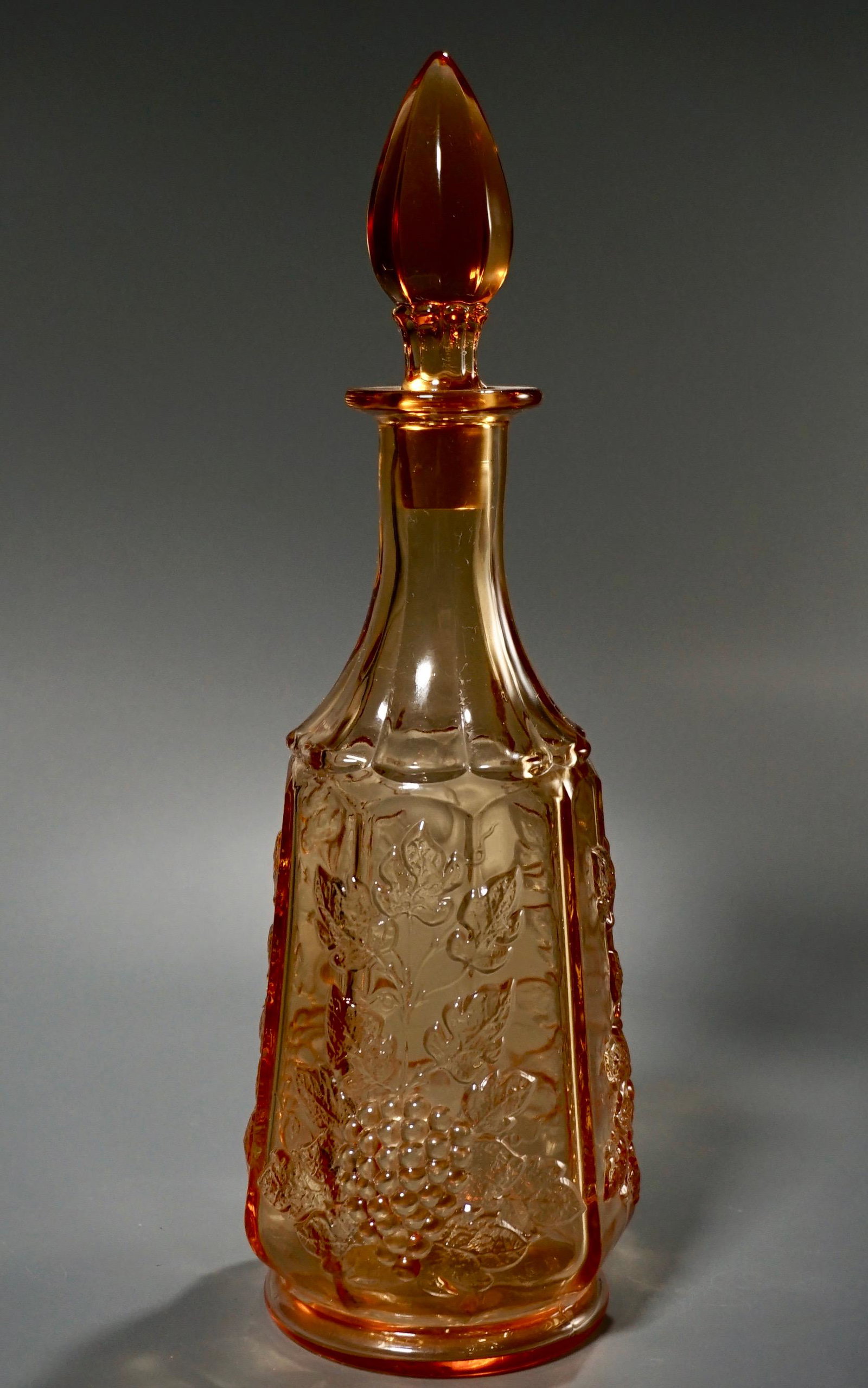 Vintage Amber Pressed Glass Wine Decanter Grape Motif: Vintage Amber Pressed Glass Wine Decanter Grape Motif Faceted Stopper Approximately 13 1/16 inches tall overall.