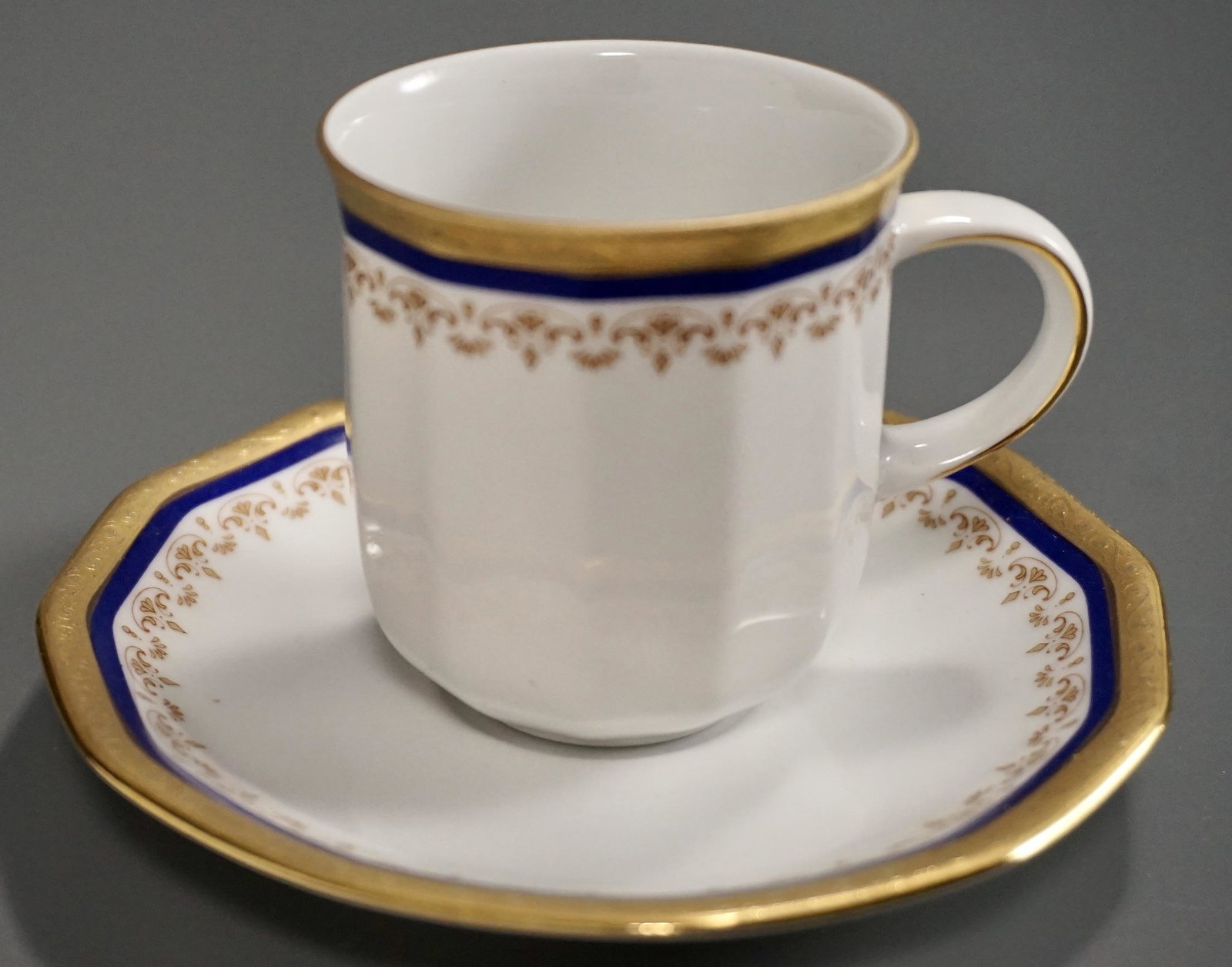 German Bavarian Gold Incrusted Cobalt Blue Trimmed: German Bavarian Gold Incrusted Cobalt Blue Trimmed Porcelain Demitasse Coffee Cup Saucer Set Cup is approximately 3 2/16 x 2 3/8 inches tall; the saucer is about 4 5/8 inches in diameter.