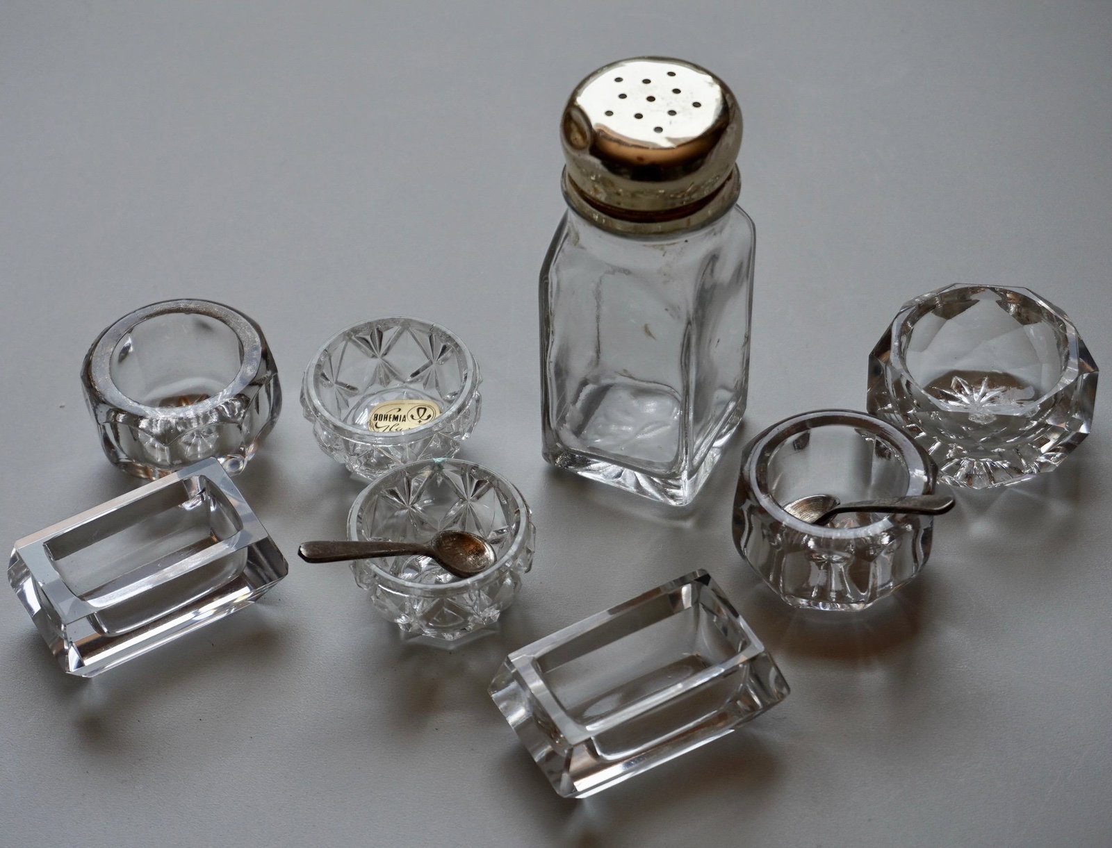 Lot of Crystal Salt Cellars Bowls Glass Shaker and 2: Lot of Crystal Salt Cellars Bowls Glass Shaker and 2 Spoons Approximately From 1 5/8 to 2 1/4 inches in diameter; shaker is 4 inches tall.