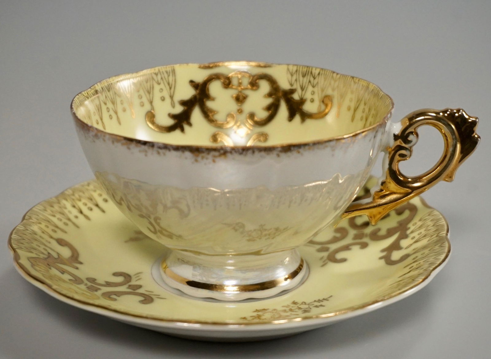Mid Century Yellow Gold Porcelain Tea Cup Saucer Set: Mid Century Yellow Gold Porcelain Tea Cup Saucer Set Cup is about 5 1/16 x 3 15/16 x 2 5/16 inches tall, the saucer is approximately 5 5/8 inches in diameter.