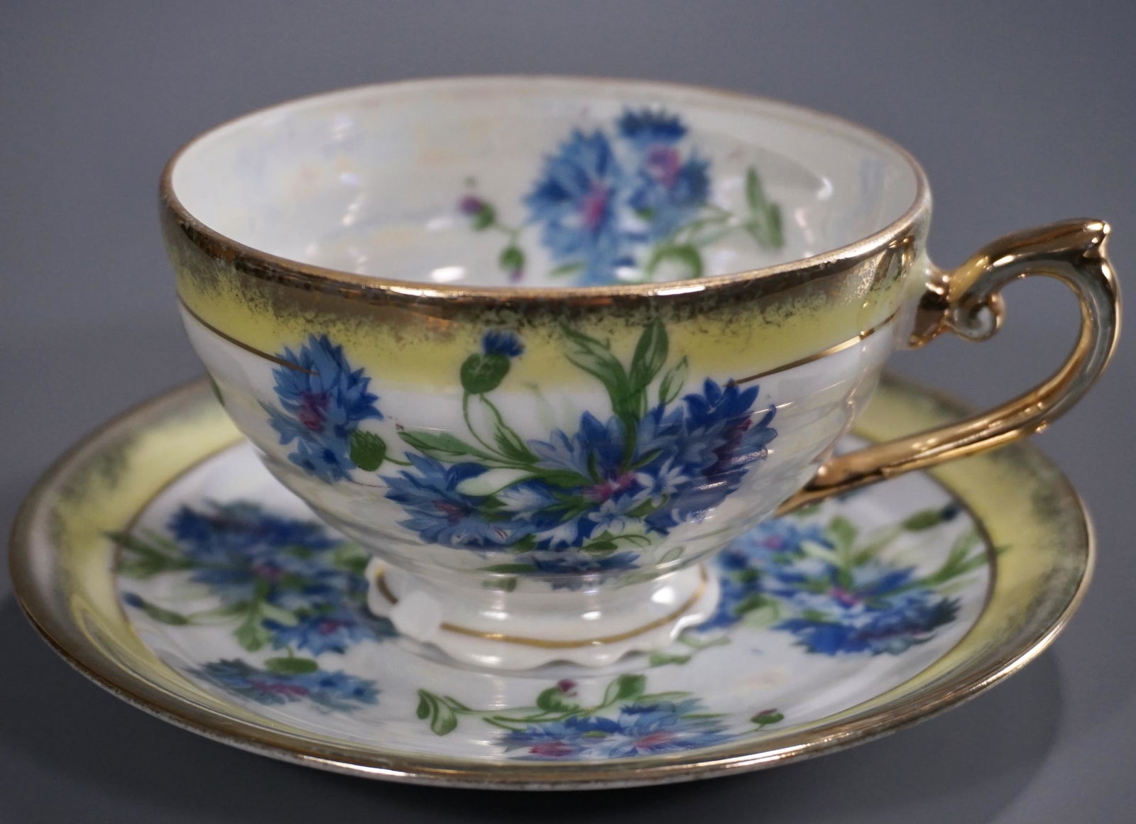 Cornflower Mid Century Iridescent Porcelain Tea Cup: Cornflower Mid Century Iridescent Porcelain Tea Cup Saucer Set Cup is approximately 4 3/4 x 3 7/8 x 2 3/8 inches tall; the saucer is about 5 11/16 inches in diameter.