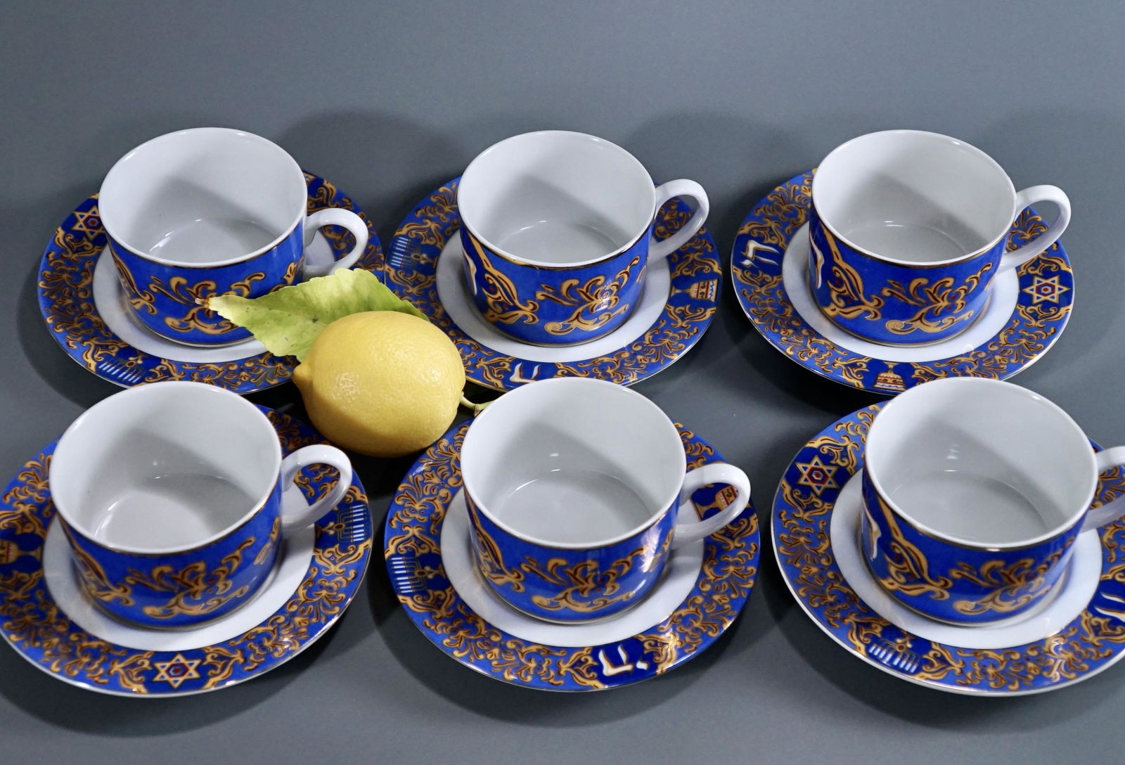 Blue Judaica Porcelain Shabbat Cup Saucer Set Lot of 6: Blue Judaica Porcelain Shabbat Cup Saucer Set Lot of 6 American Atelier Tea Cups and Saucers Cups are approximately 4 1/2 x 3 1/2 x 2 1/4 inches tall; the saucers are about 6 1/8 inches in diameter.