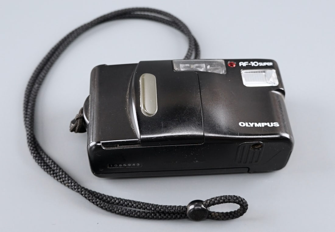 Olympus AF-10 Super 35 mm Film Camera: Olympus AF-10 Super 35 mm Film Camera Approximately 4 5/8 inches wide. Shipping Estimate:SHIPTHEBAY estimate for shipping of this lot in the Continental US is $20, which includes pick up, packing and 