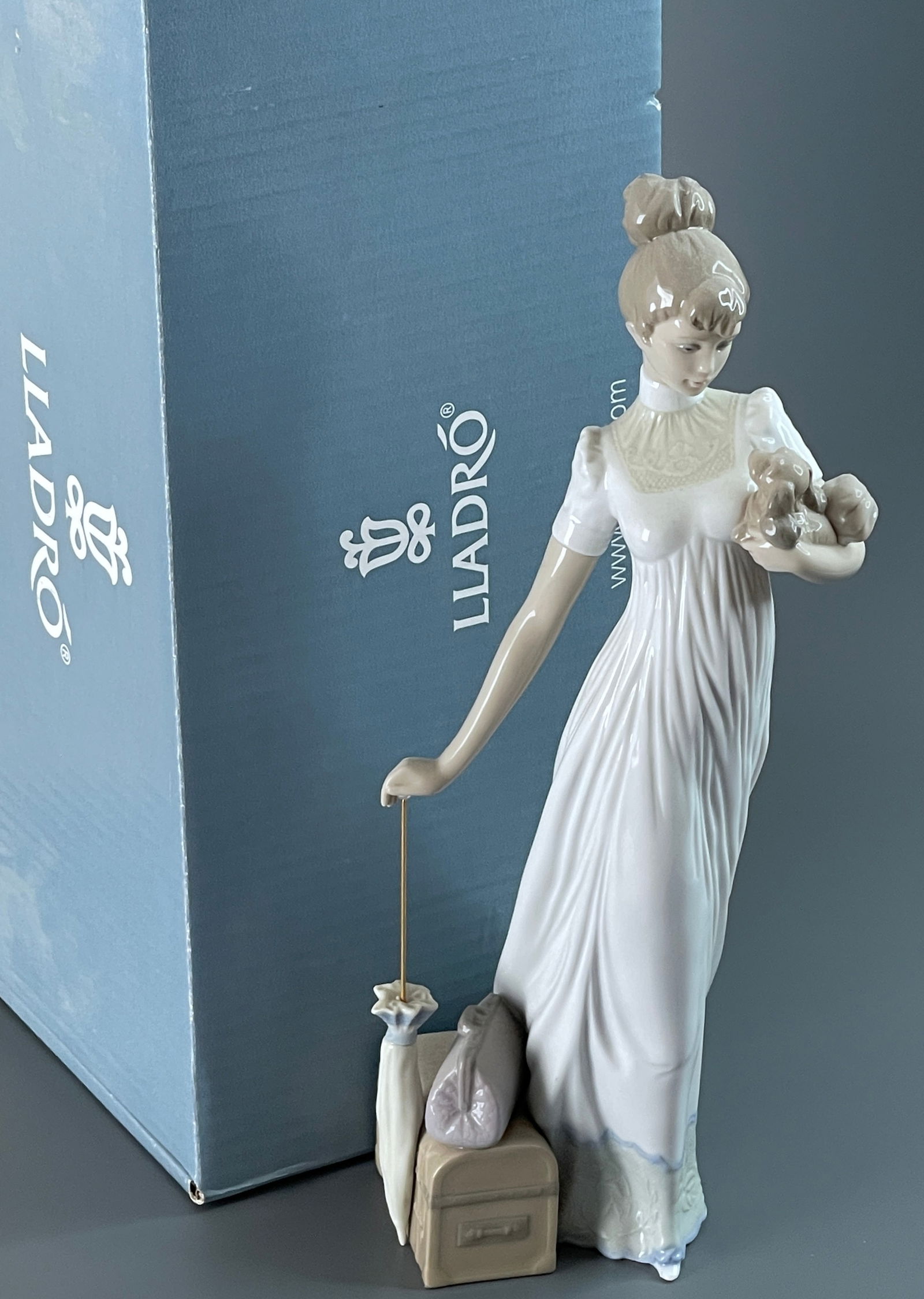 Traveling Companions 01006753 Elegant woman figurine in glossy porcelain with an umbrella in one (1 of 4)