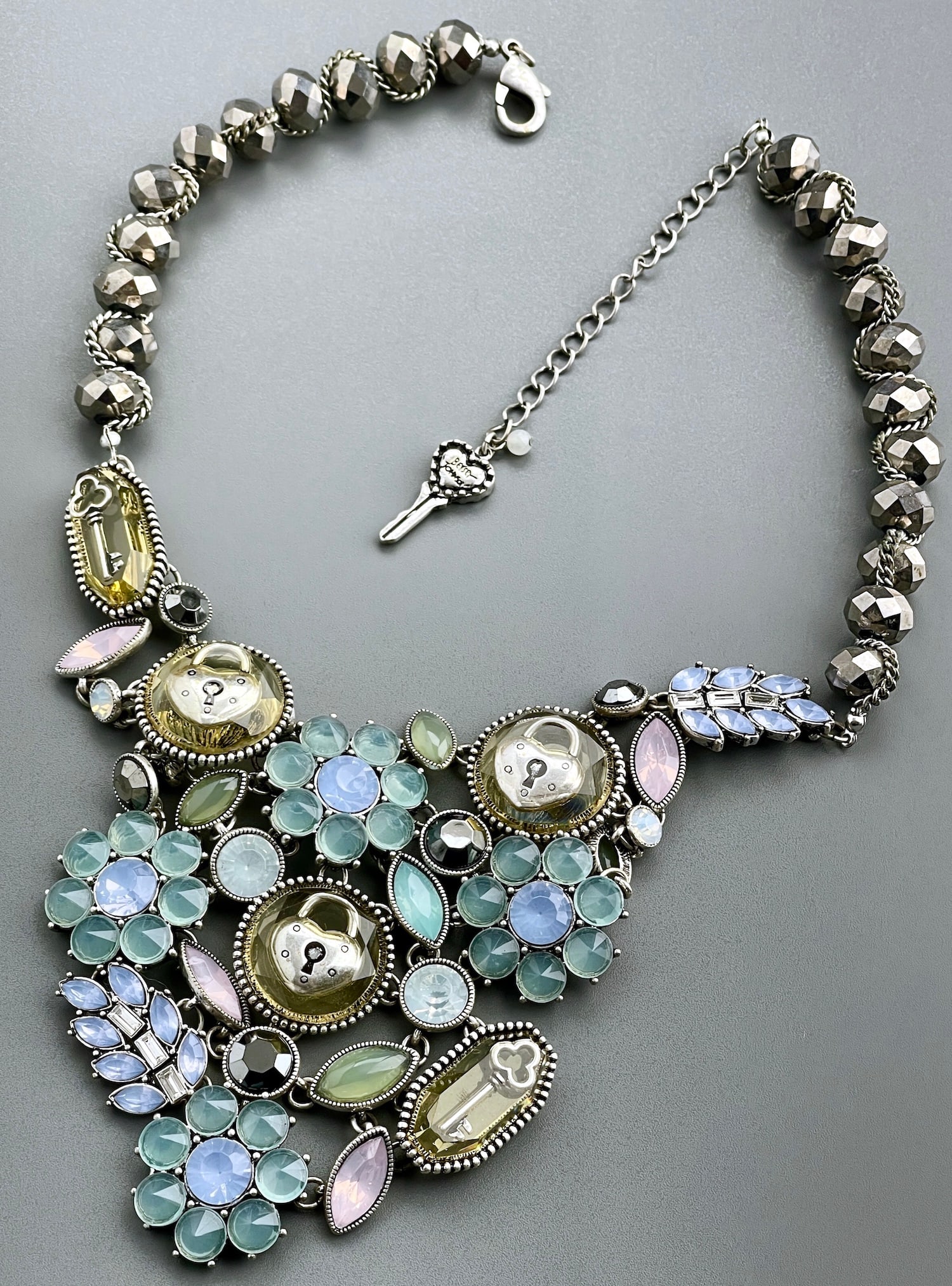 Betsey Johnson Lock & Key Rhinestone Necklace with Teal Flowers: Betsey Johnson Lock & Key Rhinestone Necklace with Teal Flowers Approximately 21 inches side to side.