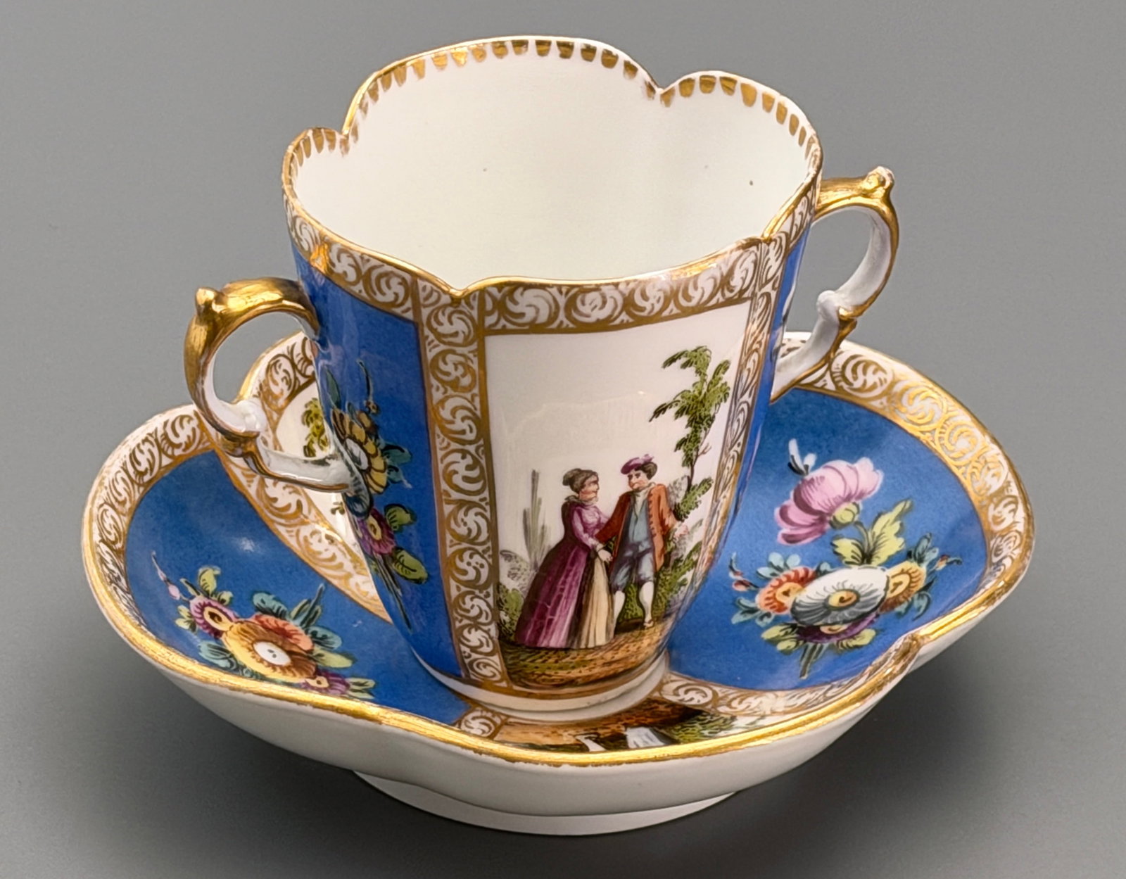 Augustus Rex Helena Wolfsohn Studio Dresden Porcelain Double Handled Quatrefoil Cup Saucer Circa: Augustus Rex Helena Wolfsohn Studio Dresden Porcelain Double Handled Quatrefoil Cup Saucer Circa Late 19th Century decorated in Meissen revival style hand painted Watteau style courtiers in pastoral s