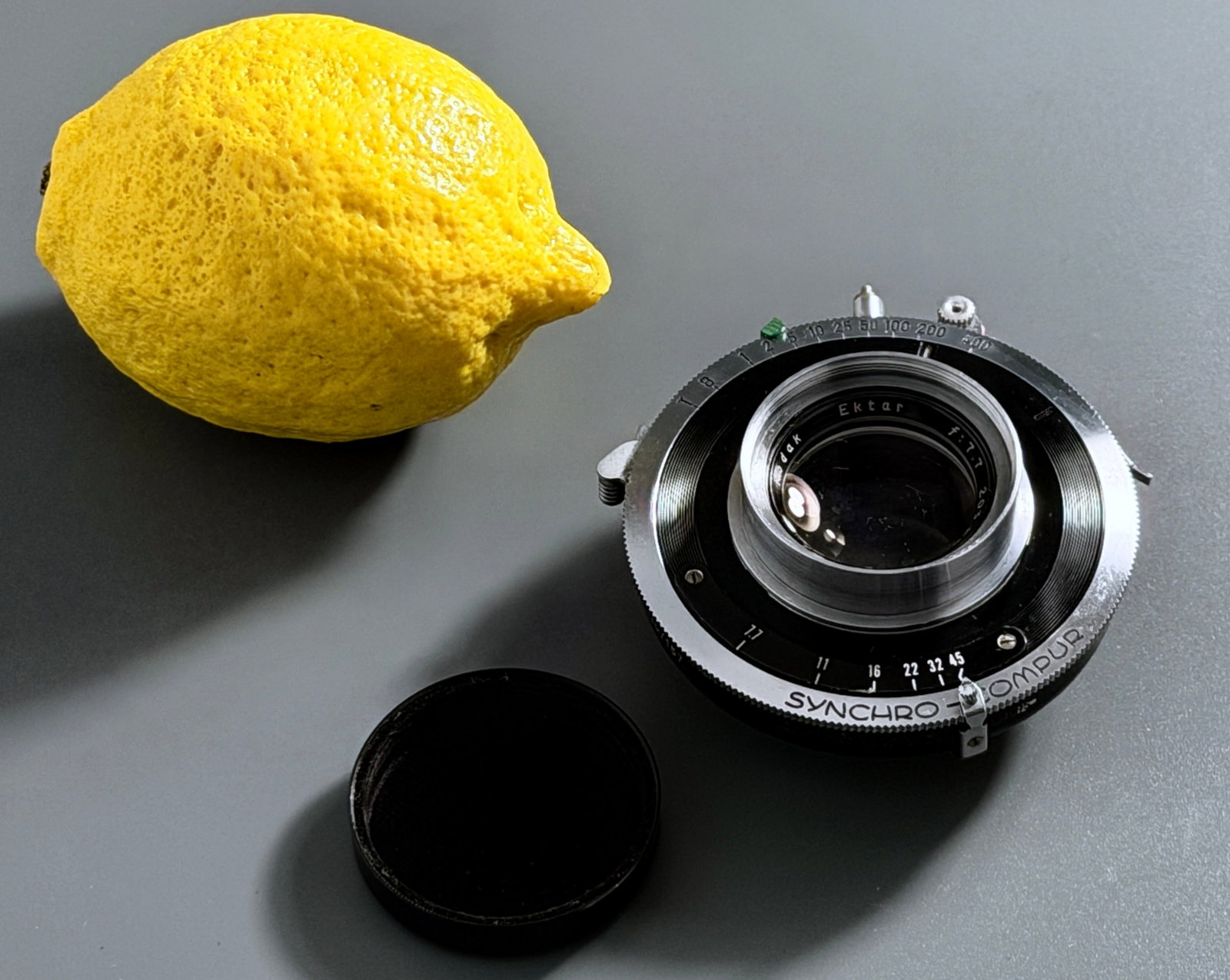 Kodak Ektar 4x5 Field Camera 203mm f7.7 Lens in Graphic Synchro Compur Shutter Original Retaining: Kodak Ektar 203mm f/7.7 Large Format Lens in Graphic Synchro-Compur Shutter Vintage Professional Optics 1955 Approximately 2 x 3 x 3 inches overall.