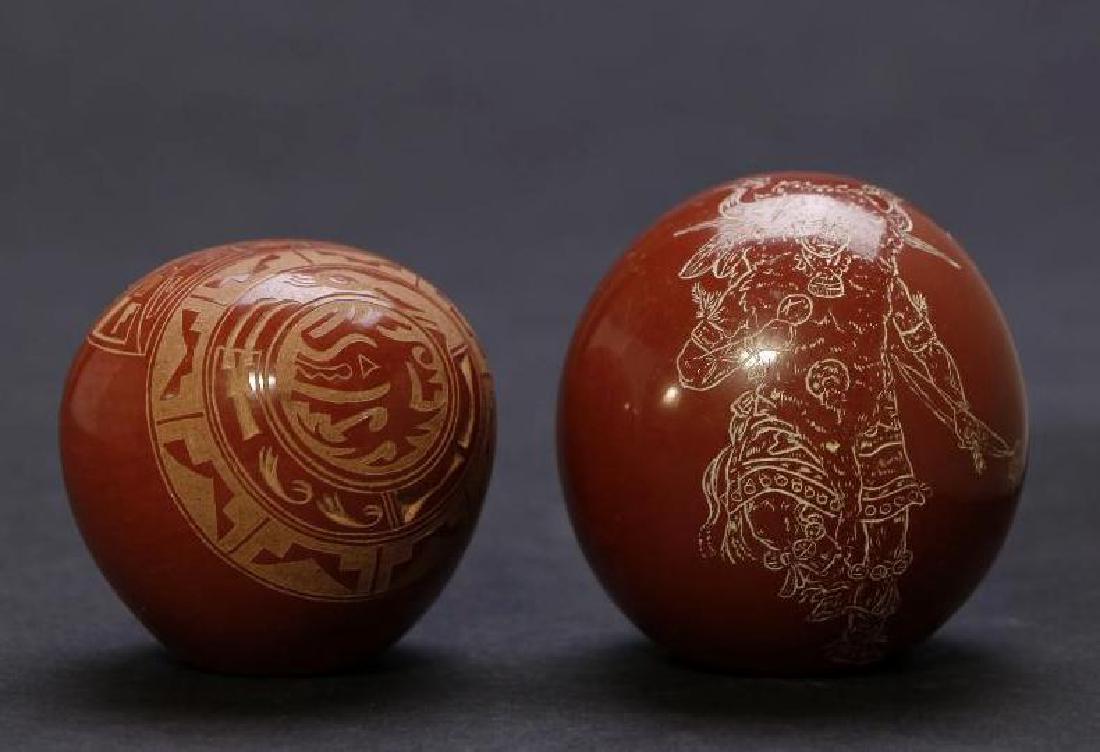 Two Santa Clara redware sgraffito pottery jars: One with the avanyu water serpent design, signed Grace Medicine Flower, 1974, the other showing a Buffalo dancer, Speckled Rock, 1985. Greatest example height: 2 1/4 inches Greatest example width: 2 i
