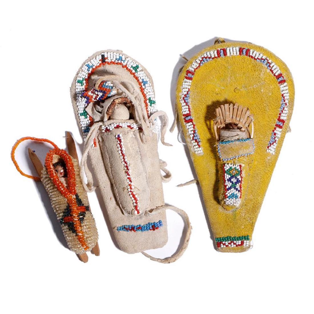 THREE NATIVE AMERICAN BEADED MODEL CRADLES: Two Paiute, each with basketry hood; and a Cheyenne example. Length 6 3/4, 6 and 3 7/8 inches